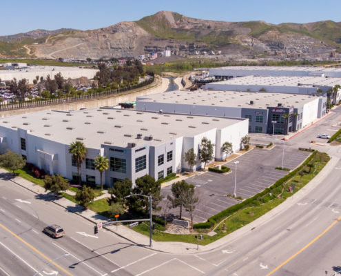 Large industrial building with Proarmour sign and mountains in the background