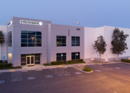 Large industrial building with Proarmour sign and mountains in the background