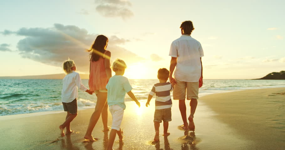 A family walks along a beach